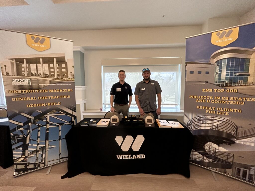 Two guys huddled around a table smiling and ready to serve