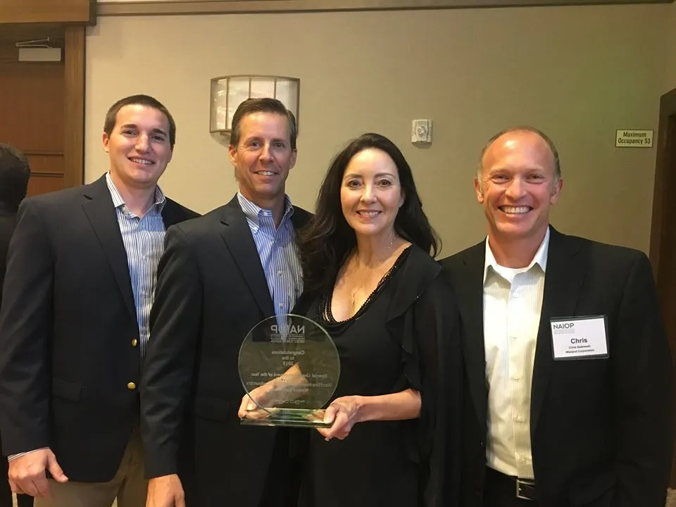 Four team member stand with their award