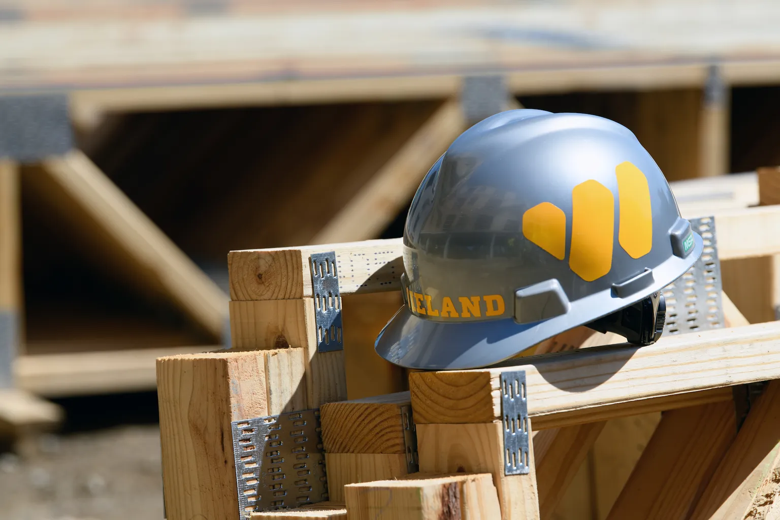 WIELAND-branded hard hat sits atop wood frames in bright sunlight.