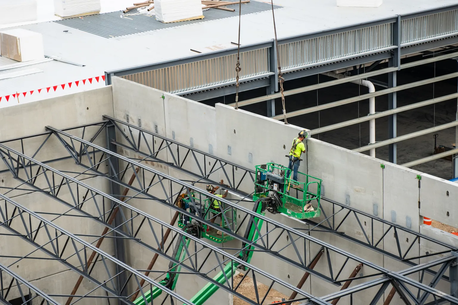 Employee stands on an unfinished second level of a project in progress.