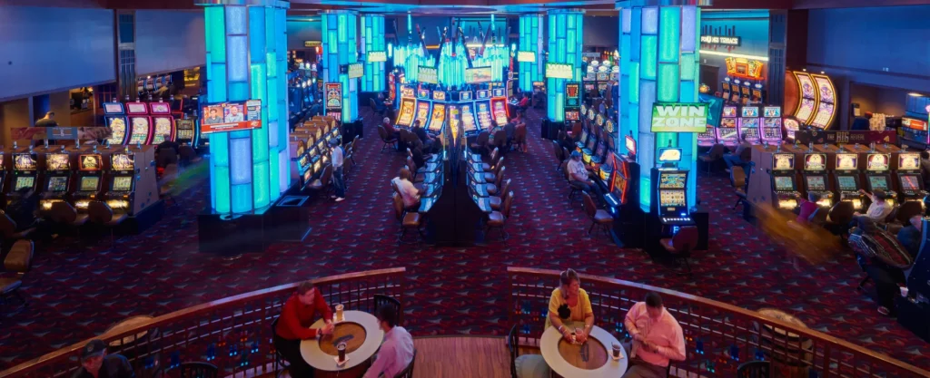 A bustling casino scene at Banco Casino, featuring numerous slot machines and players engaged in gaming activities.