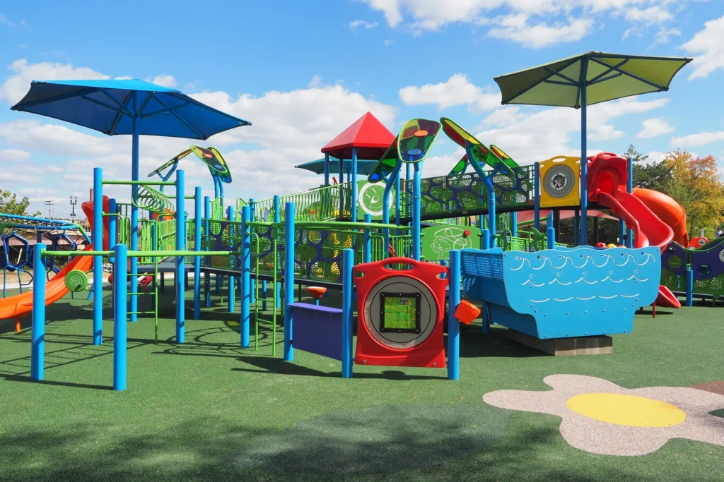 Colorful playground equipment with slides and swings located at PlayMichigan in Lansing, Michigan.