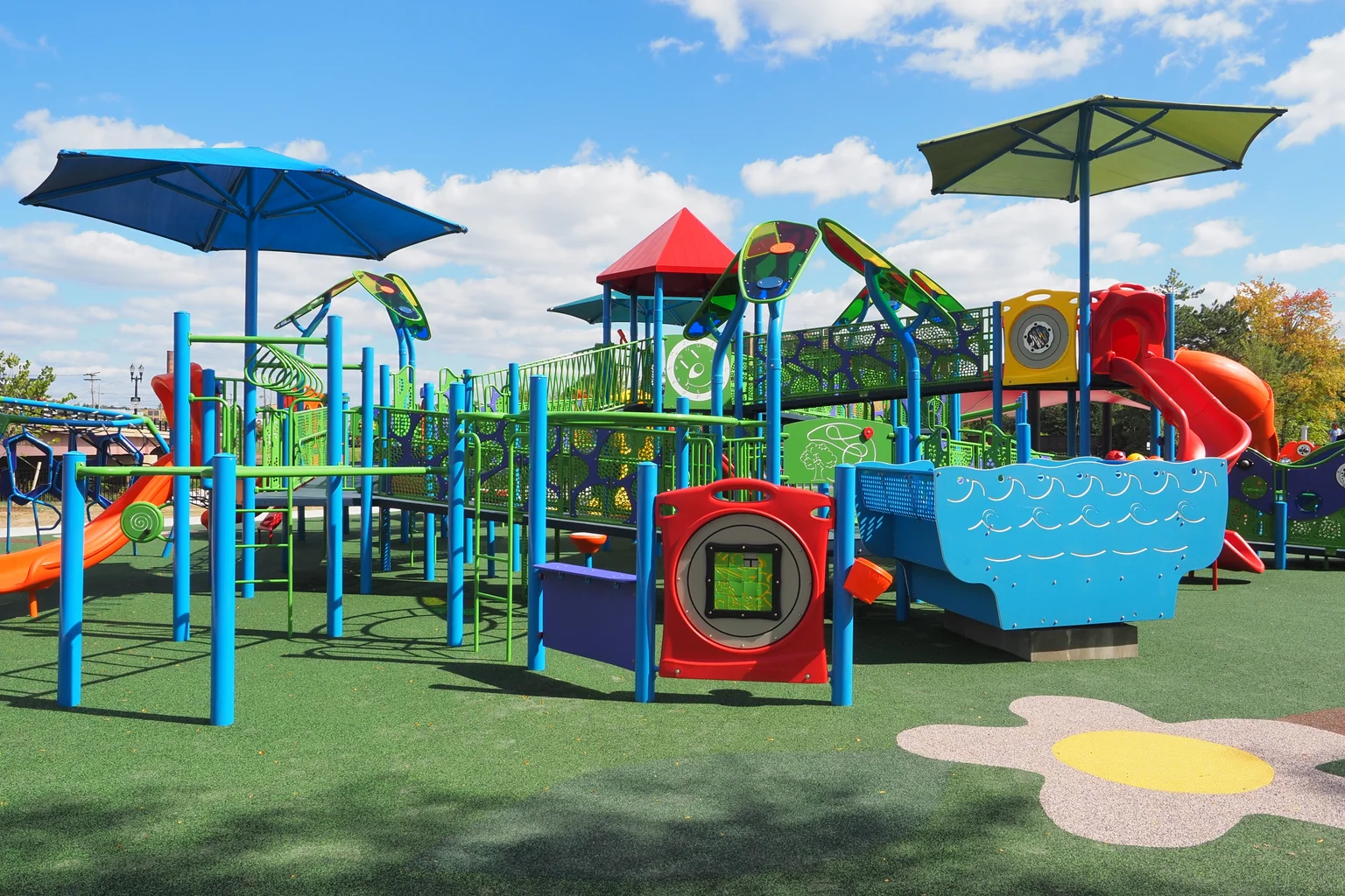 Colorful playground equipment with slides and swings located at PlayMichigan in Lansing, Michigan.