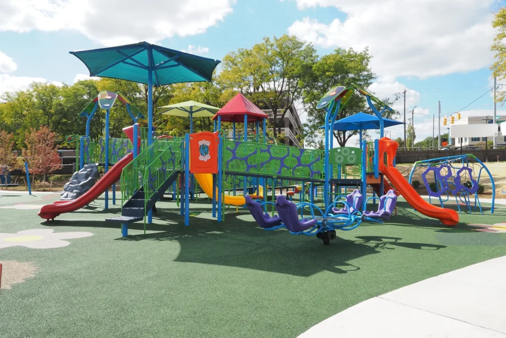 A lively playground in Lansing, MI, showcasing bright slides and swings, inviting children for outdoor fun.