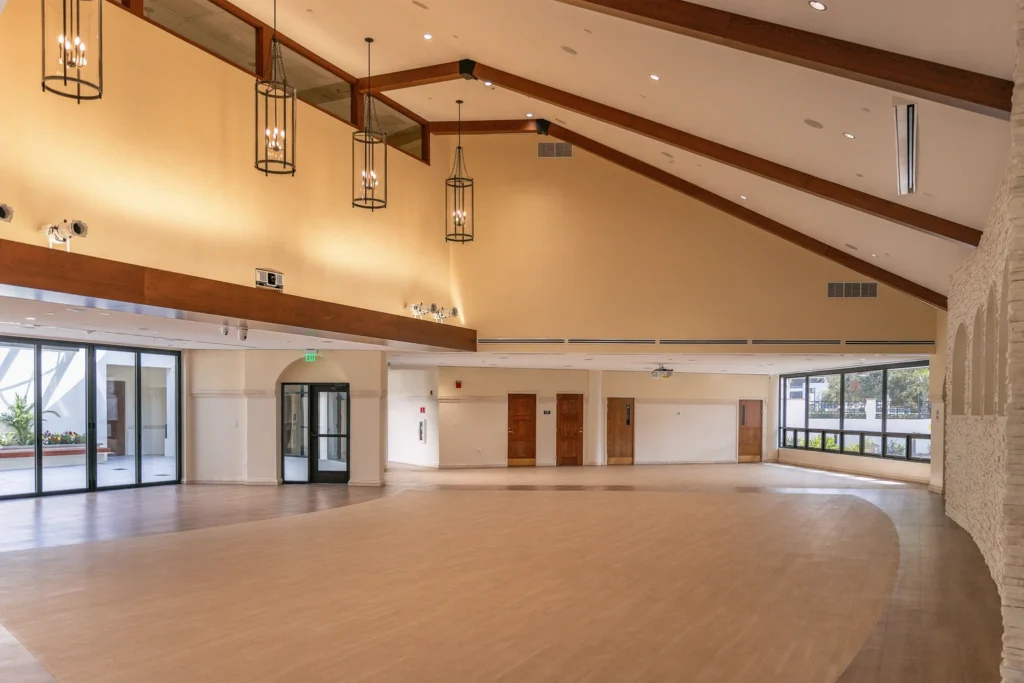Large room interior of St. James Catholic Church, Orlando, FL, showcasing polished wooden floors.