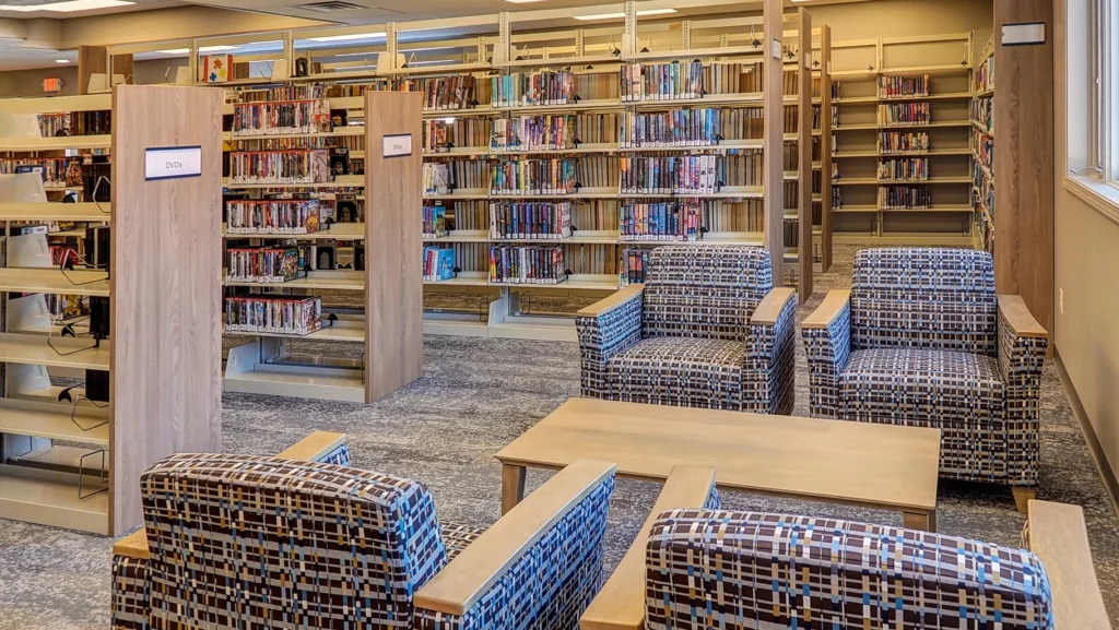 A view of the reading area in Briggs District Library, St. Johns, MI, with chairs and tables arranged for visitors