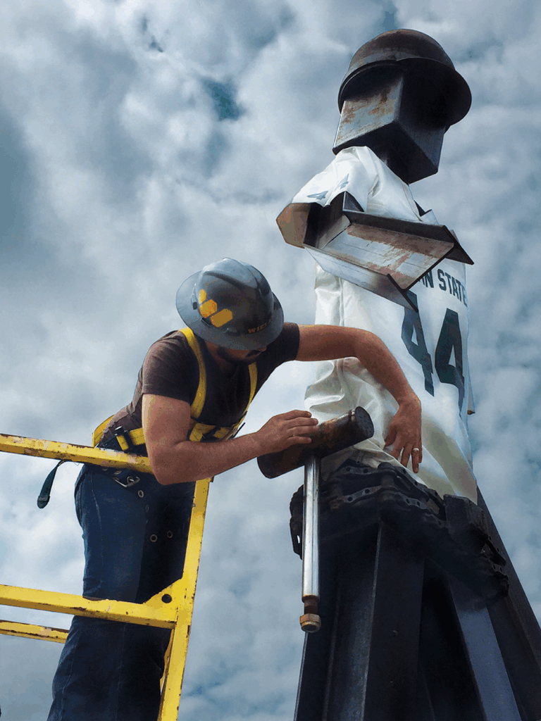 WIELAND employee carefully places a spartan jersey on an art installation