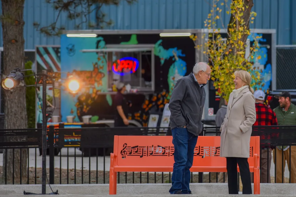 Group of individuals gathered in conversation at the grand opening of the Fish Ladder Music Park. 