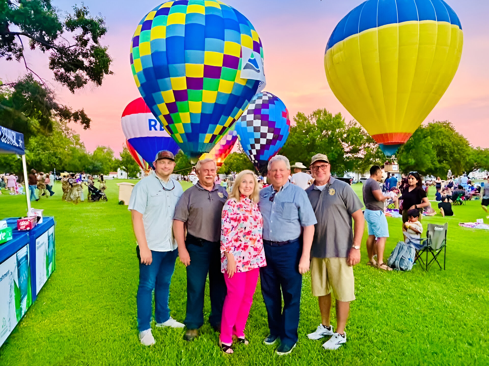 Group standing together with hot air balloons in the background