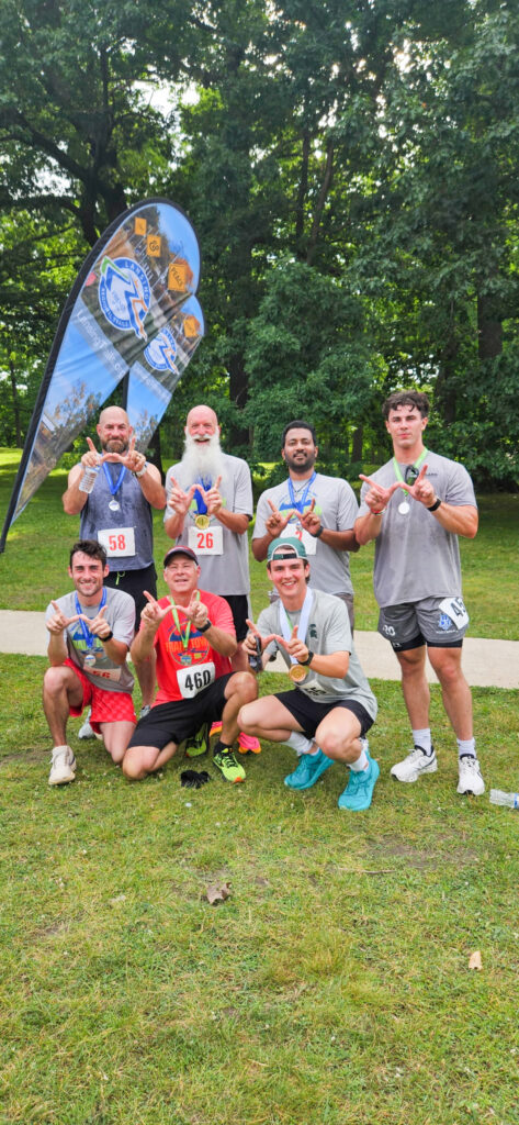 Group of runners celebrating their results while holding up the WIELAND "W".