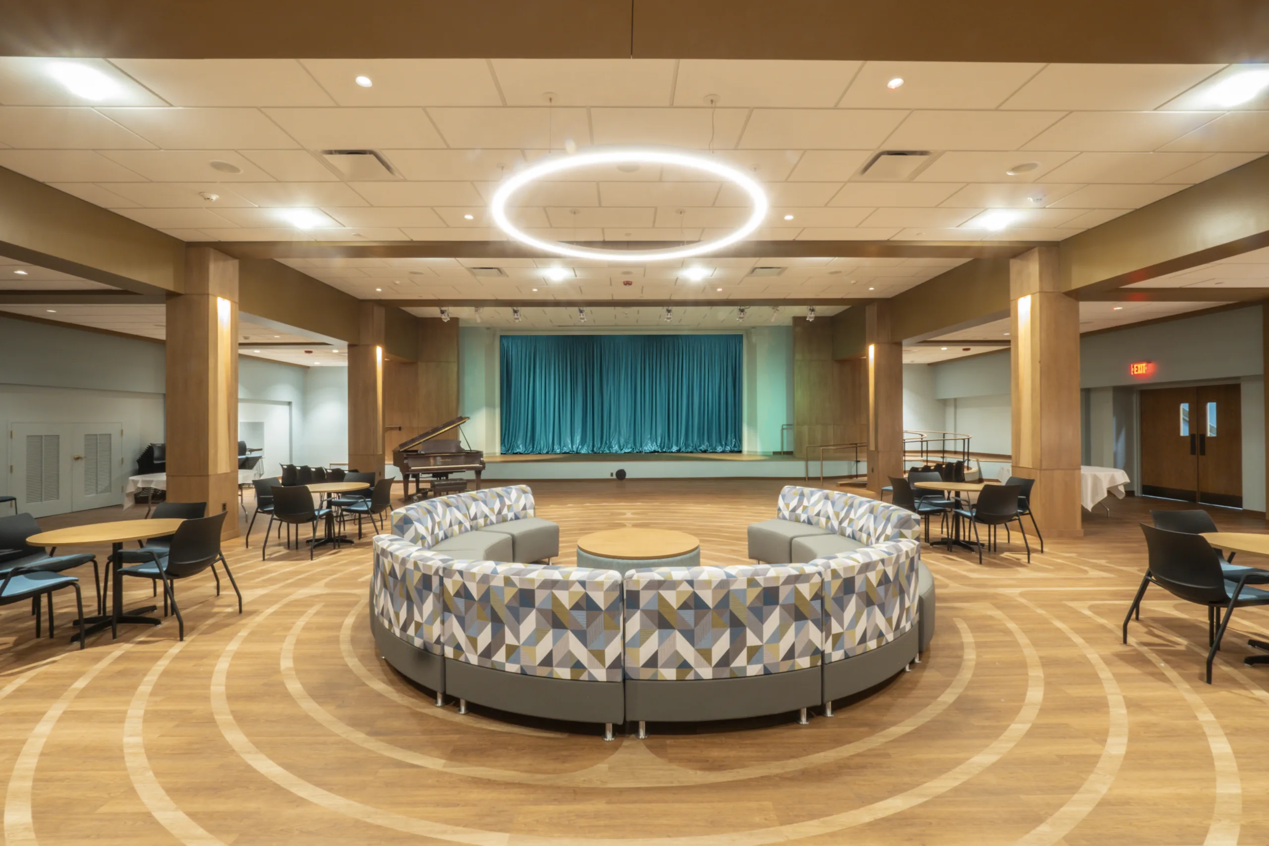 Photo showing the seating area and grand piano in the lower-level social hall.