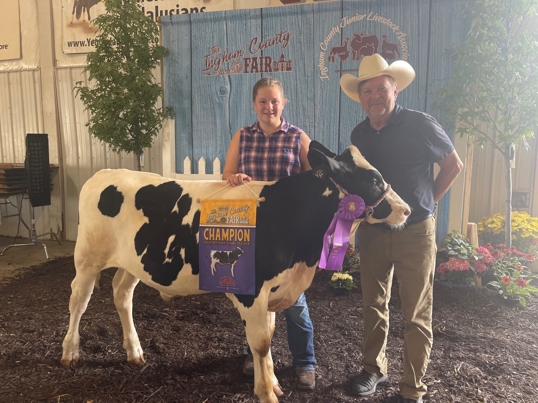 Two individuals gathered for a photo around the champion steer!