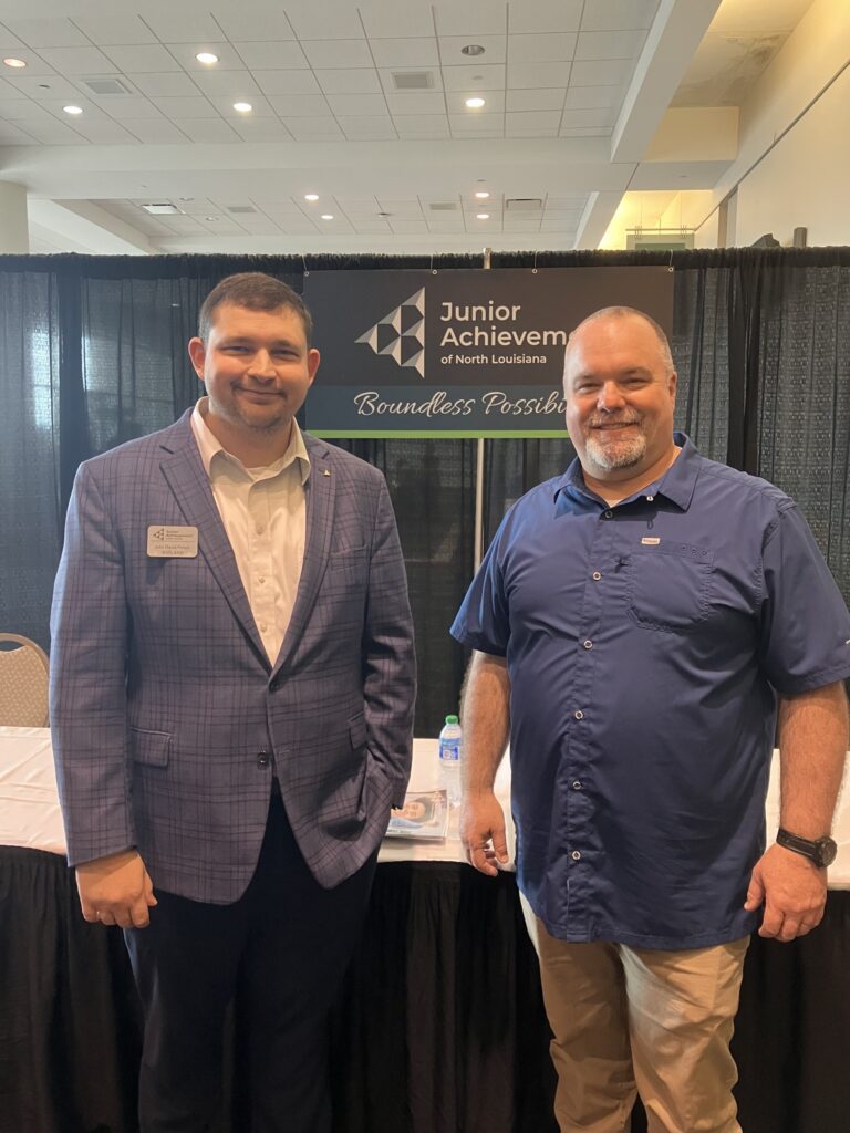 Two men gather for a photo around the JA table