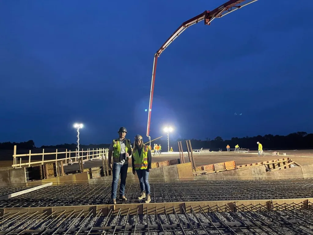 Two individuals standing at the front of the pour holding their thumbs up 