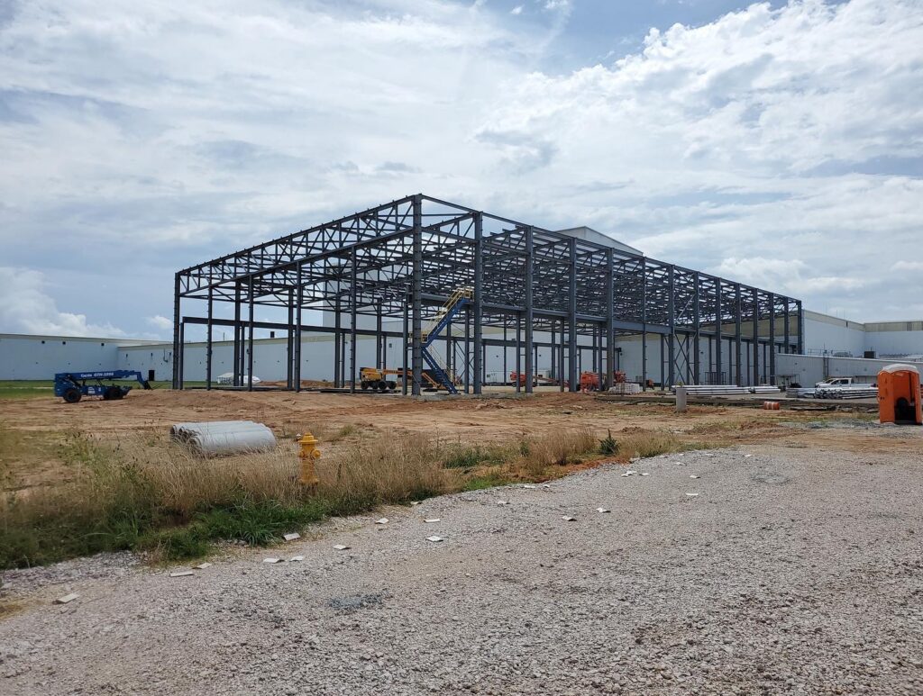 Photo showing the exterior of the building as the steel is being erected.