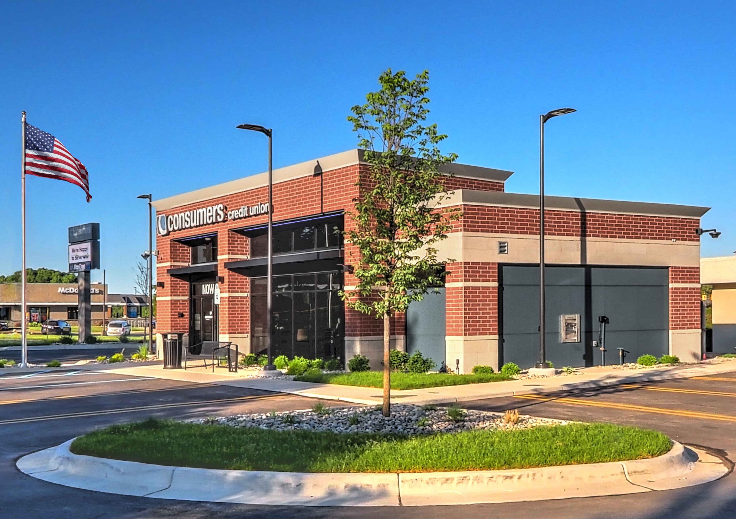 Exterior view of the Consumers Credit Union Rockford Office. The American flag is waving in the background and the brick building is in the foreground.
